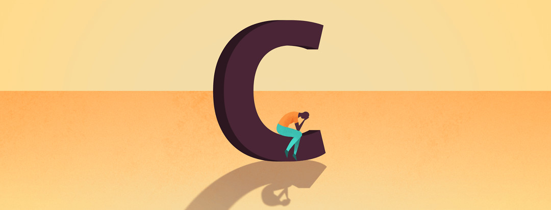 a man sitting in a large 'C' with his head in his hands
