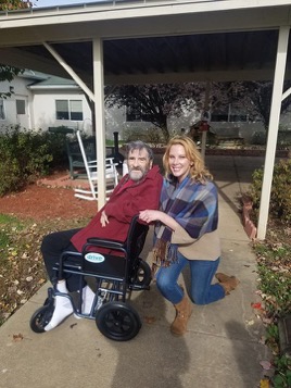 Katie next to her grandfather in wheelchair outdoors