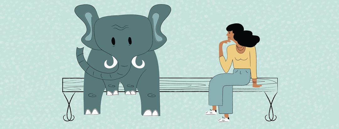 A large elephant sitting on bench next to a woman