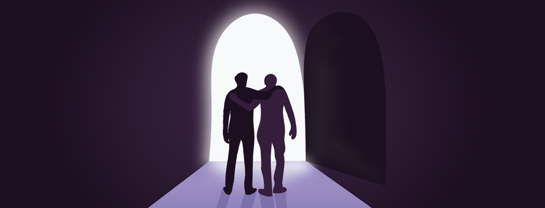 two men in a dark space walking down a path toward a doorway of light