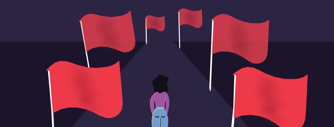 a woman standing on a path with red flags lining the sides of it