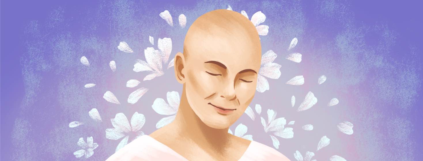A woman with a shaved head smiles, surrounded by flowers.