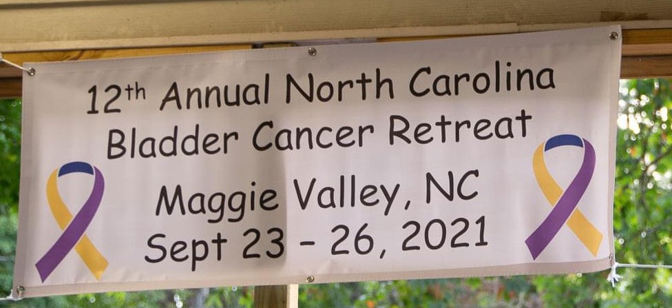Sign reads: 12th Annual North Carolina Bladder Cancer Retreat. Maggie Valley, NC. Sept 23-26, 2021